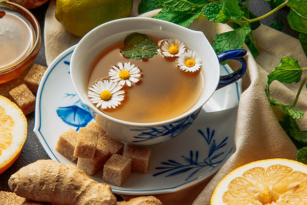 Tisanes-chamomile-tea-with-slices-of-lemon,-ginger,-brown-sugar-cubes